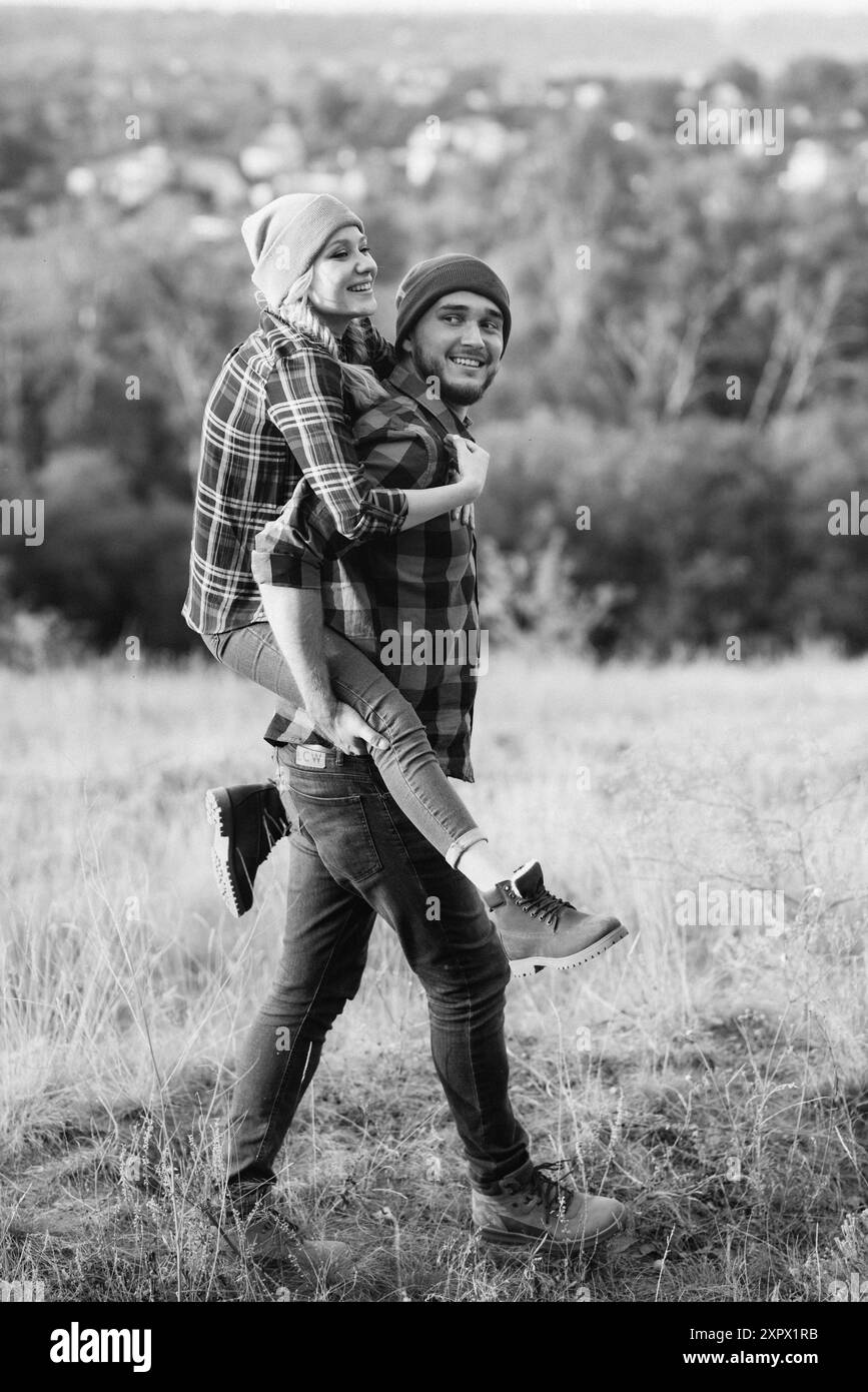 Ragazzo allegro e ragazza su una passeggiata in maglia brillante cappelli e camicie plaid Foto Stock