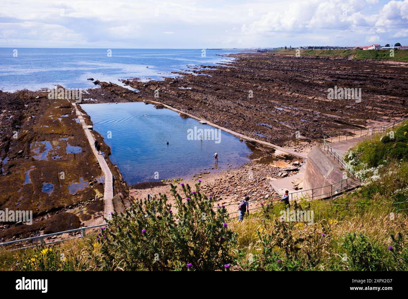 Piscina all'aperto con acqua di mare a Pittenweem, Scozia, con St Monans sullo sfondo Foto Stock