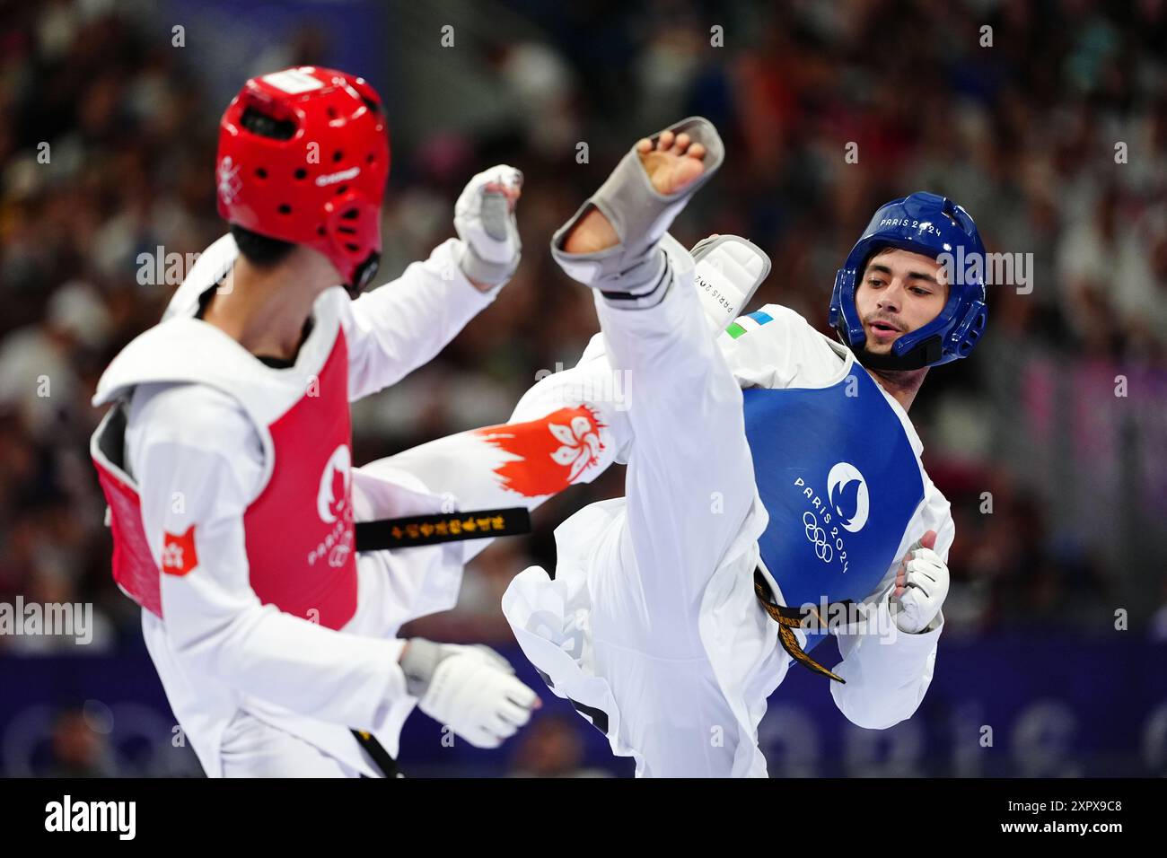 Ulugbek Rashitov (a destra) dell'Uzbekistan e Hong Kong, lo Wai Fung della Cina durnig il Taekwondo maschile -68kg Round of 16 al Grand Palais il tredicesimo giorno dei Giochi Olimpici di Parigi del 2024 in Francia. Data foto: Giovedì 8 agosto 2024. Foto Stock