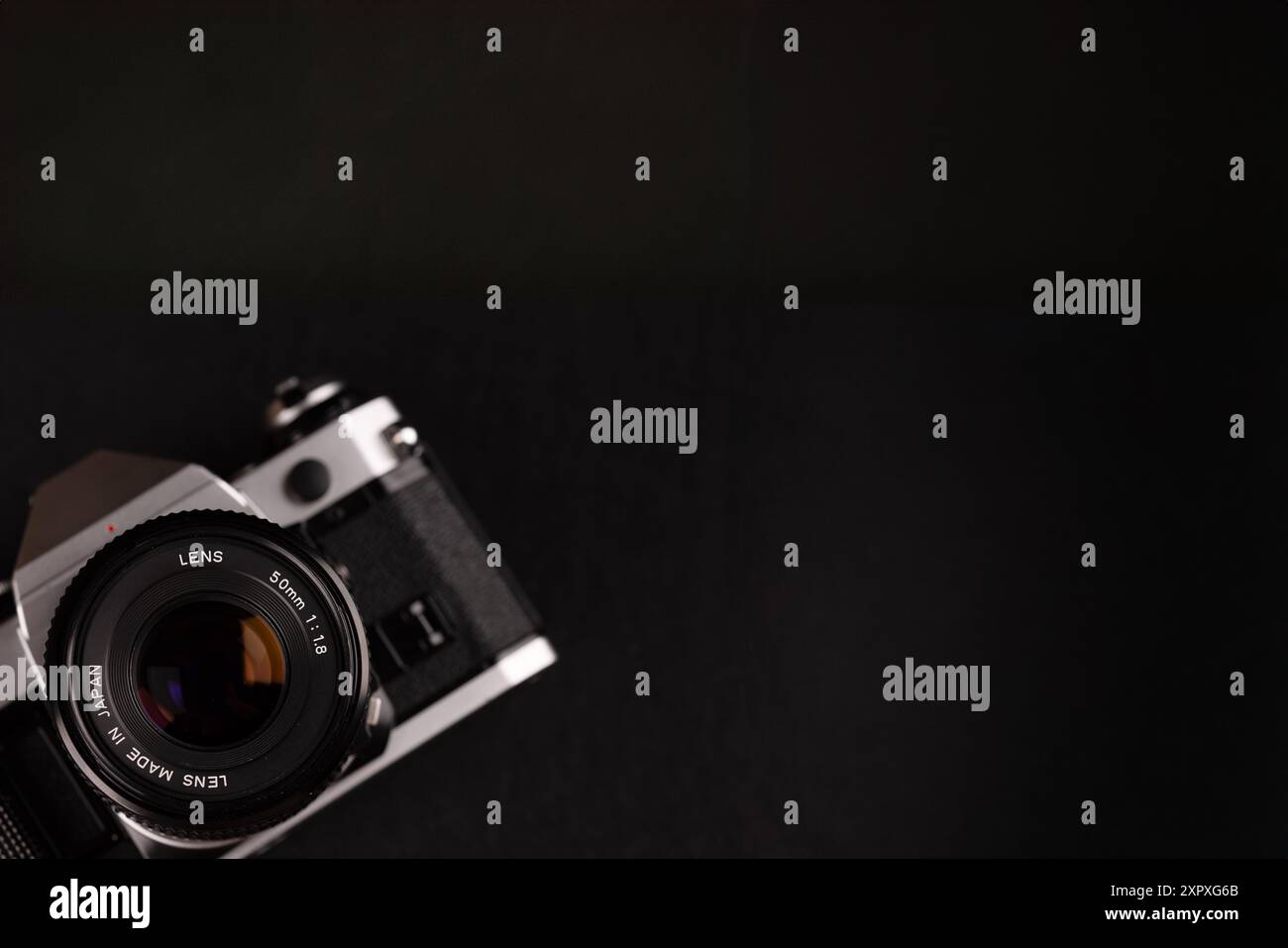 Una videocamera vintage presente nell'angolo sinistro con un ampio sfondo nero, che mostra l'eleganza delle vecchie attrezzature fotografiche. Foto Stock