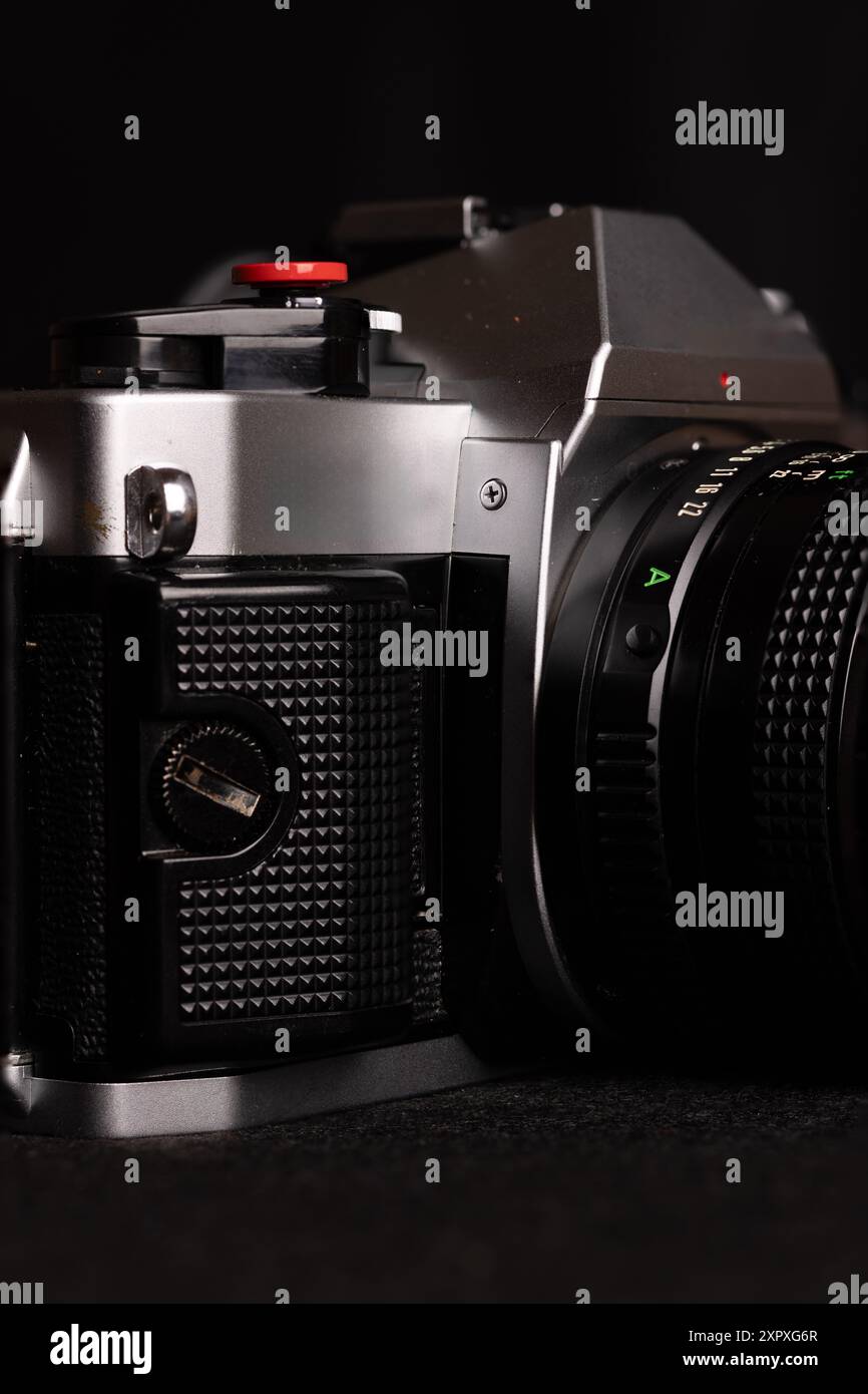 Primo piano di una vecchia videocamera, ripresa verticale con sfondo nero. L'immagine mette in risalto la bellezza senza tempo della fotografia analogica. Foto Stock