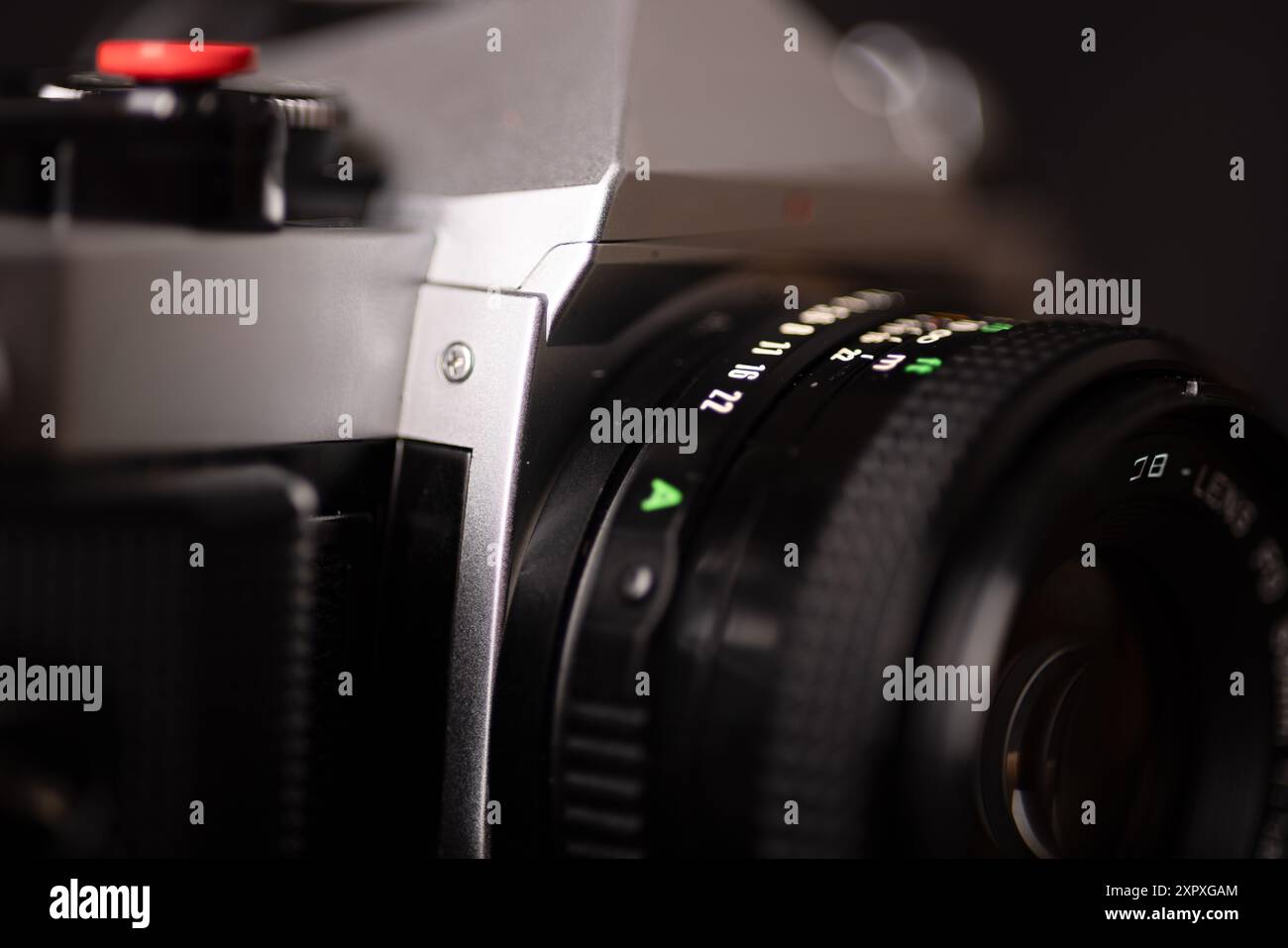 Primo piano di un obiettivo di una fotocamera vintage, evidenziato su uno sfondo scuro. Ideale per scattare foto nel giorno del fotografo. Foto Stock