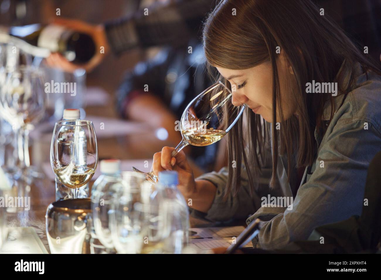Donna seduta al tavolo con un bicchiere di vino Foto Stock