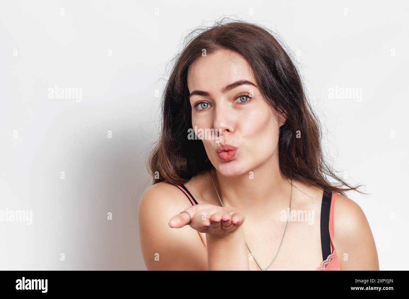 Ritratto di una donna in canotta rosa con capelli neri, invio di un bacio Foto Stock Ritratto di una donna in canotta rosa con capelli neri, invio di un bacio Foto Stock