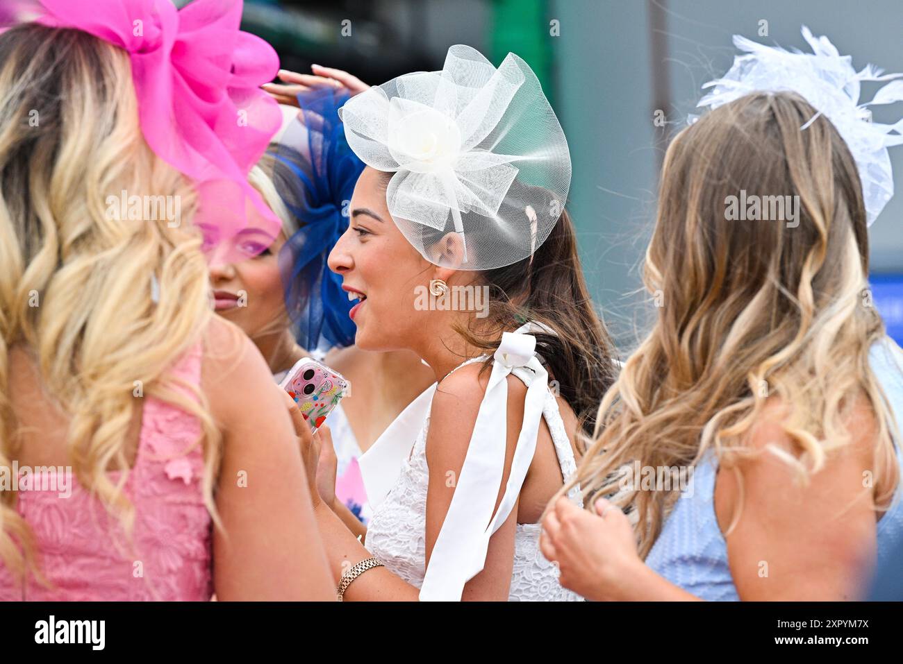 Brighton Regno Unito 8 agosto 2024 - gli amanti dei cavalli nei loro migliori cappelli e costumi al Brighton Festival of Racing Ladies Day in un pomeriggio di blustery lungo la costa meridionale: Credit Simon Dack / Alamy Live News Foto Stock