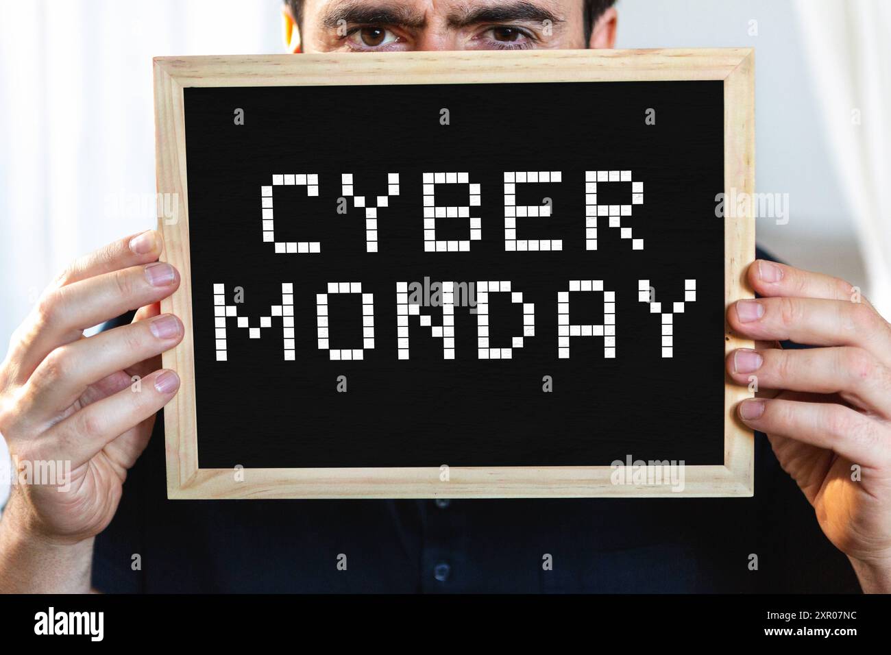 8 agosto 2024: Cliente con in mano un cartello con l'iscrizione: Cyber Monday. FOTOMONTAGGIO *** Kunde hält ein Schild mit Aufschrift: Cyber Monday. FOTOMONTAGE Foto Stock