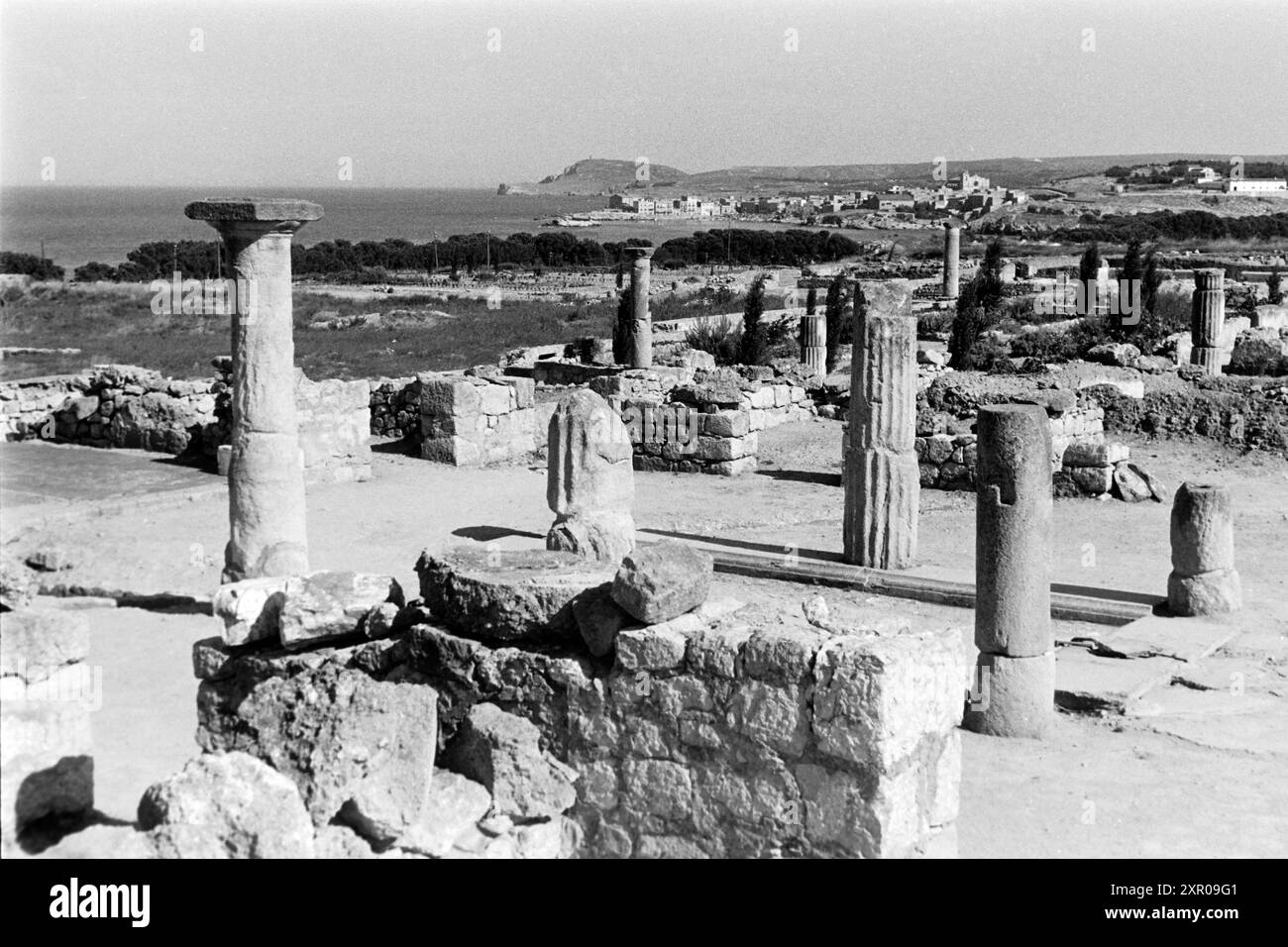 Reste von Mauern und dorischen Säulen zeichnen die Neapolis, den neueren griechisch-iberischen Teil von Empúries, aus, hier befand sich unter anderem das Asklepieion, ein Heiligtum, das Äskulap, dem Gott der Heilkunst, gewidmet War und zu dem üblicherweise ein Sanatorium gehörte, Costa Brava 1957. Resti di mura e colonne doriche caratterizzano la Neapolis, la più recente parte greco-iberica di Empúries, che era il sito che includeva l'Asclepieion, un santuario dedicato ad Asclepio, il dio della guarigione, e che di solito includeva un sanatorio, Costa Brava 1957. Foto Stock
