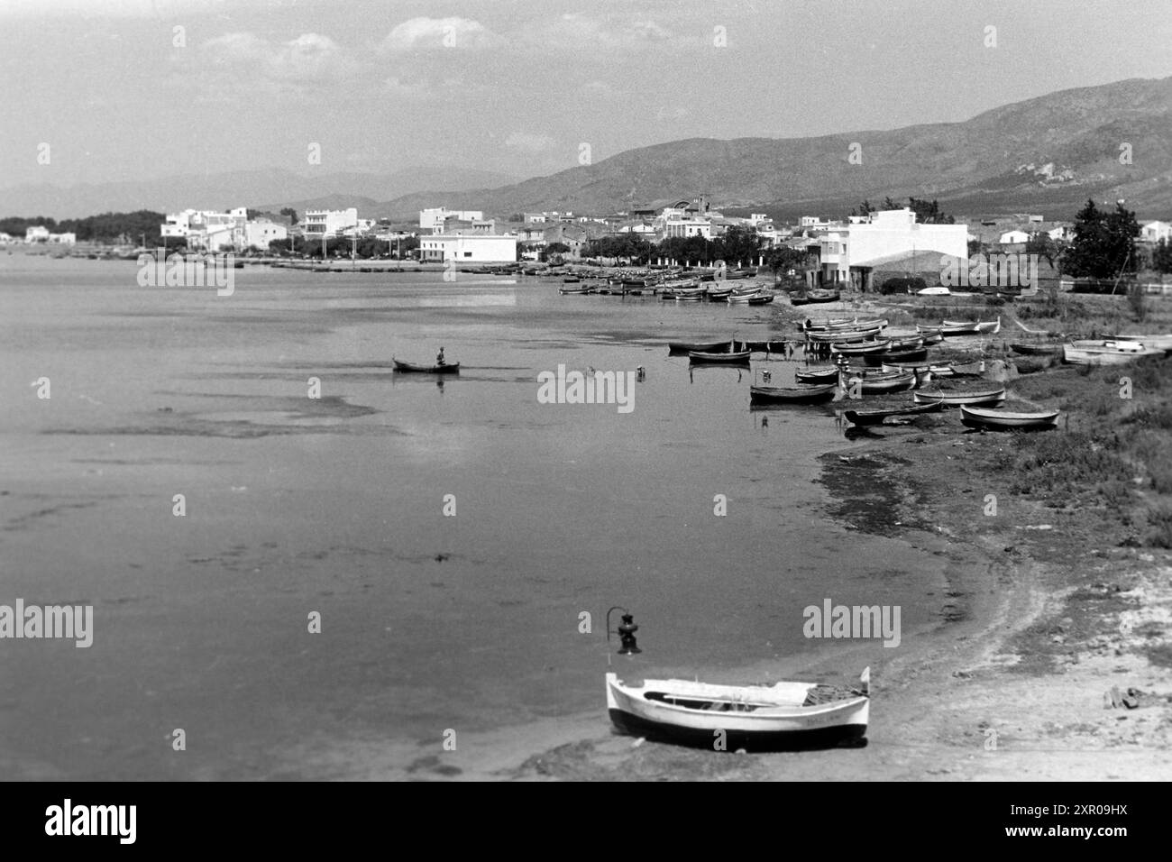 Fischerboote liegen am Strand von El Port de la Selva, deren Häuser im Hintergrund an den Ausläufern der Pyrenäen liegen, Cap de Creus 1957. Barche da pesca ormeggiate sulla spiaggia di El Port de la Selva, con case sullo sfondo ai piedi dei Pirenei, Cap de Creus 1957. Foto Stock