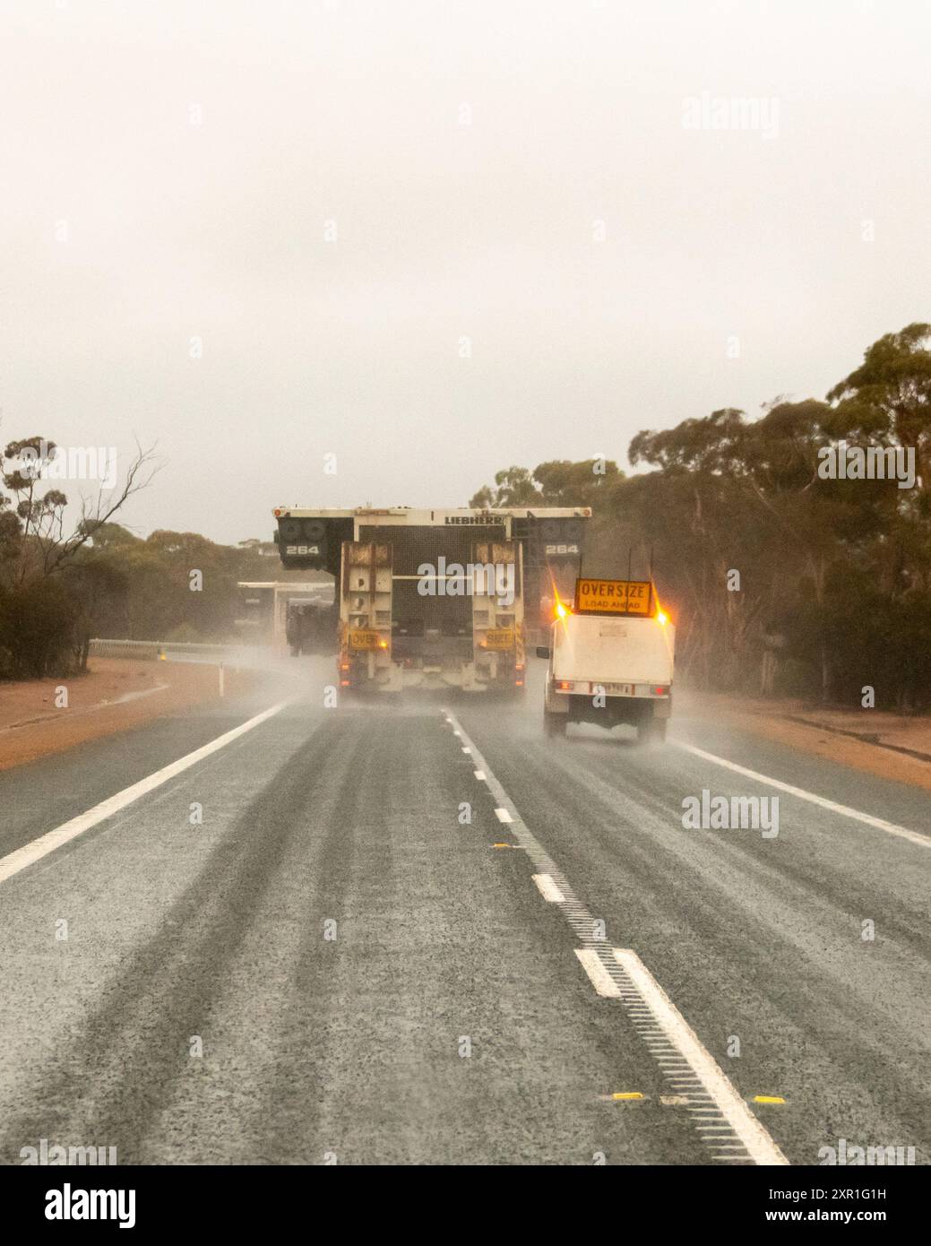 Grande pezzo di attrezzatura mineraria trasportato con scorta. Foto Stock