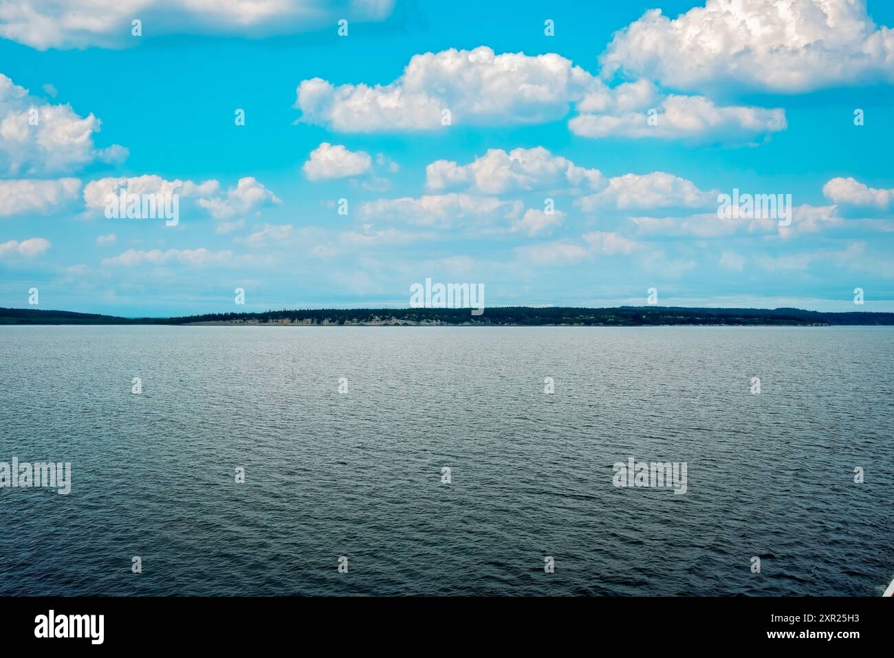 Crociera in Alaska sotto un cielo blu con nuvole bianche e soffici e costa Foto Stock