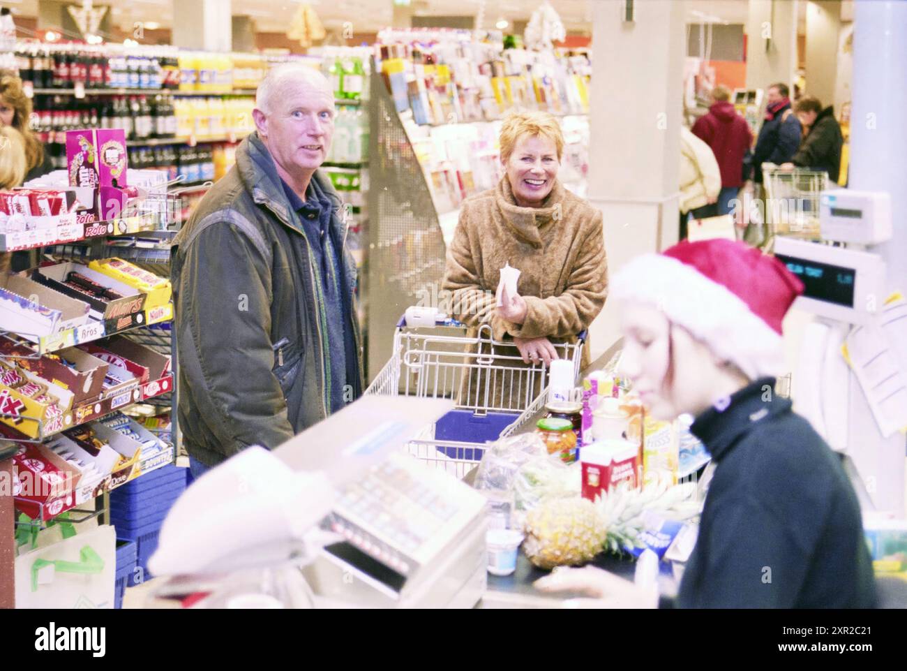 Uomo e donna che fanno shopping natalizio ad Albert Heijn, Hoofddorp (alla cassa), Hoofddorp, Paesi Bassi, 22-12-2001, Whizgle Dutch News: Immagini storiche su misura per il futuro. Esplora il passato dei Paesi Bassi con prospettive moderne attraverso le immagini delle agenzie olandesi. Colmare gli eventi di ieri con gli approfondimenti di domani. Intraprendi un viaggio senza tempo con storie che plasmano il nostro futuro. Foto Stock