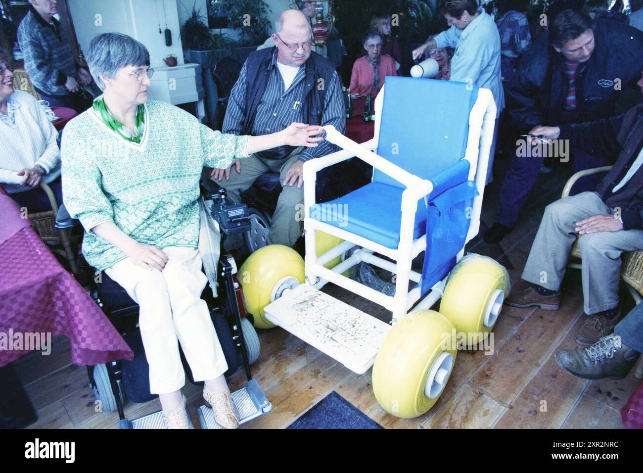 La gente guarda la sedia a rotelle sulla spiaggia, IJmuiden, 13-05-1997, Whizgle Dutch News: Immagini storiche su misura per il futuro. Esplora il passato dei Paesi Bassi con prospettive moderne attraverso le immagini delle agenzie olandesi. Colmare gli eventi di ieri con gli approfondimenti di domani. Intraprendi un viaggio senza tempo con storie che plasmano il nostro futuro. Foto Stock