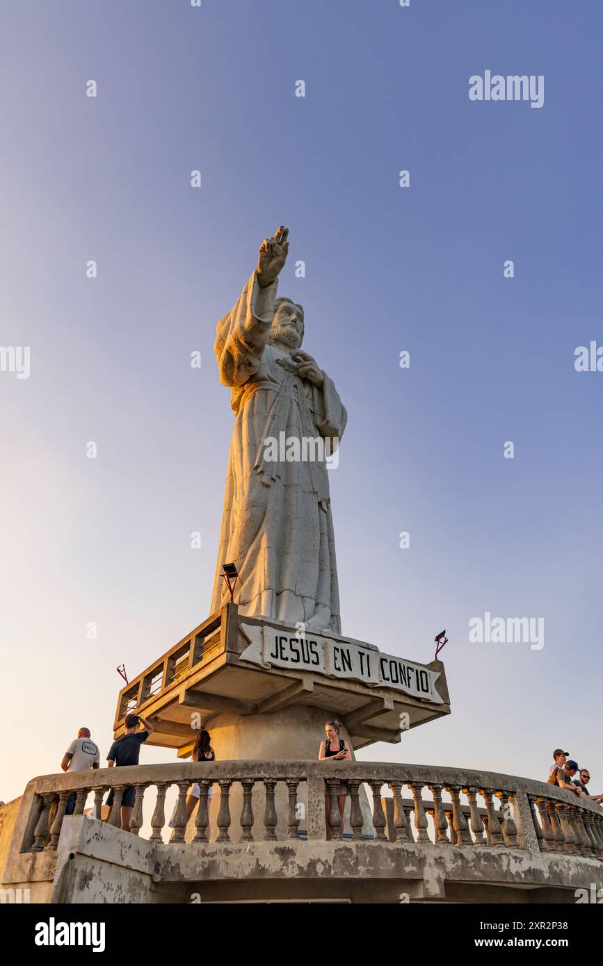 San Juan del Sur, Nicaragua - 23 marzo 2024: Imponente statua contemporanea del Cristo della Misericordia in piedi su una scogliera sopra la baia di San Juan del Sur. Foto Stock