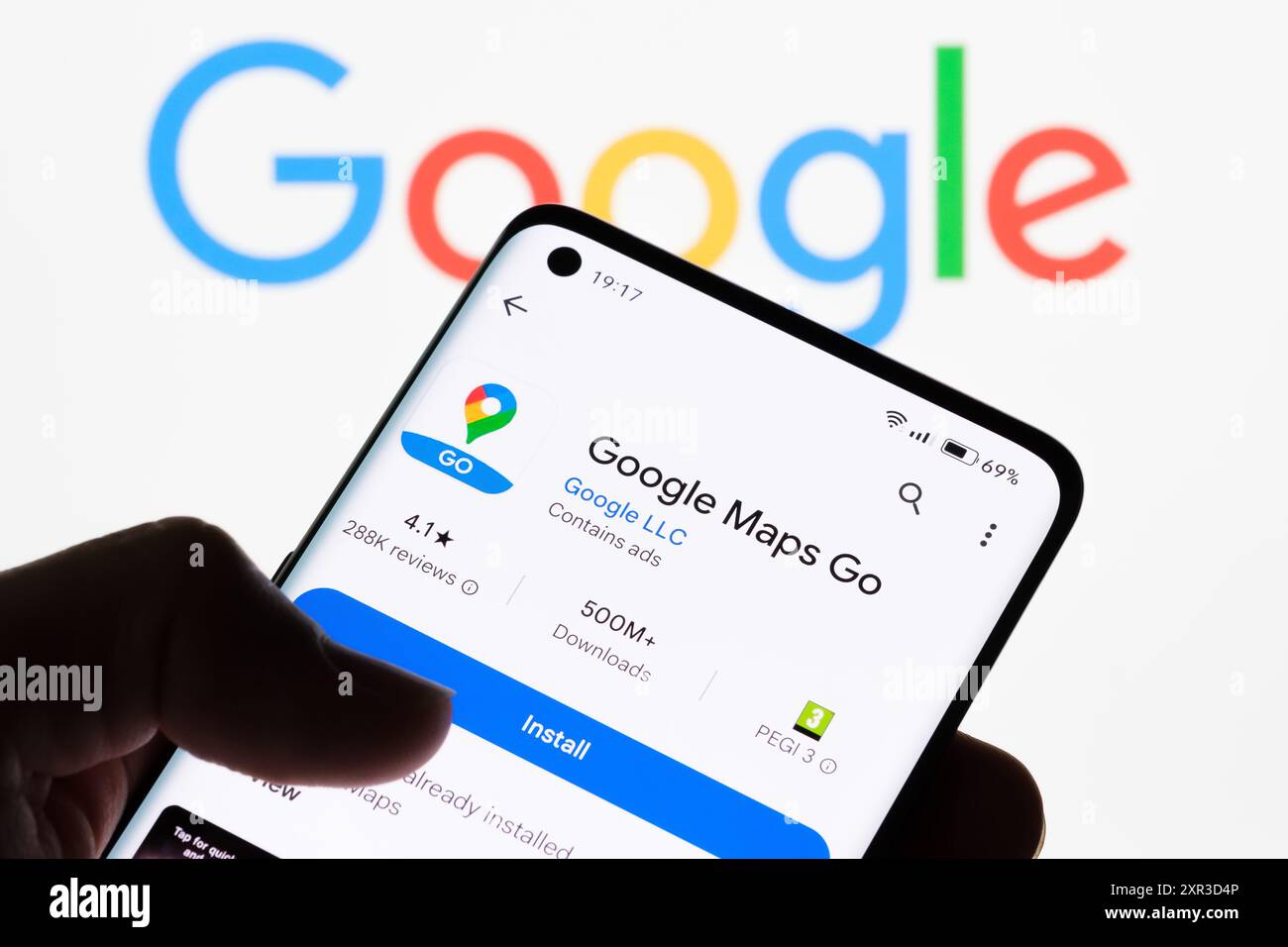 Primo piano dello schermo di uno smartphone che visualizza l'app Google Maps Go con il logo Google sullo sfondo, che mostra il collegamento tra Google Maps Go e Google, Foto Stock