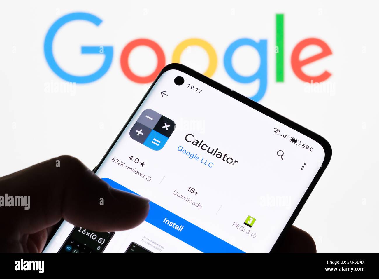 Primo piano dello schermo di uno smartphone che visualizza l'app Calcolatrice con il logo Google sullo sfondo, evidenziando la connessione tra Calcolatrice e Googl Foto Stock