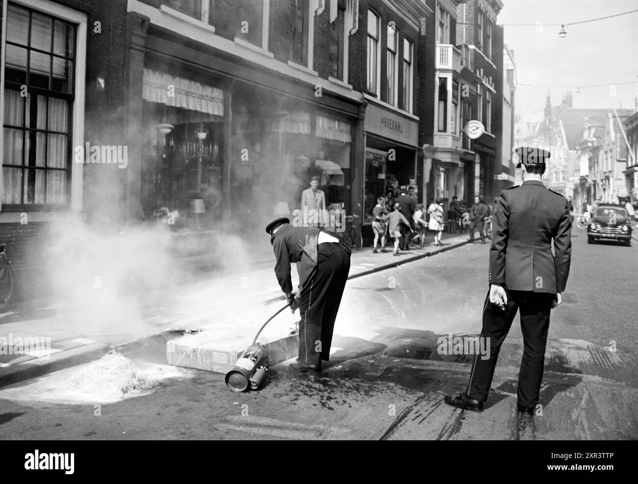 La bara, incendiata da ragazzi di fronte a un negozio di lampade a Kruisstraat, viene spenta dalla polizia. (Cfr. NHC o HD 17 agosto 1962), vigili del fuoco, Haarlem, Barteljorisstraat, The Netherlands, 16-08-1962, Whizgle Dutch News: immagini storiche su misura per il futuro. Esplora il passato dei Paesi Bassi con prospettive moderne attraverso le immagini delle agenzie olandesi. Colmare gli eventi di ieri con gli approfondimenti di domani. Intraprendi un viaggio senza tempo con storie che plasmano il nostro futuro. Foto Stock