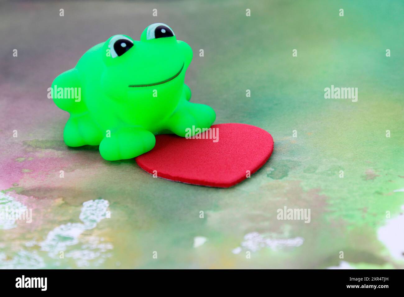 Rana innamorata attaccata a un cuore Foto Stock