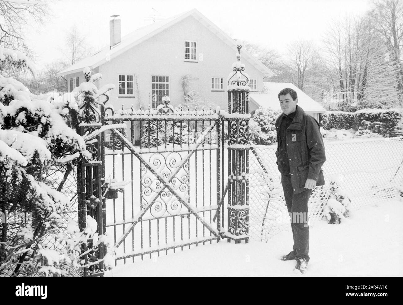Uomo accanto alla recinzione in ferro battuto nella neve, Whizgle Dutch News: Immagini storiche su misura per il futuro. Esplora il passato dei Paesi Bassi con prospettive moderne attraverso le immagini delle agenzie olandesi. Colmare gli eventi di ieri con gli approfondimenti di domani. Intraprendi un viaggio senza tempo con storie che plasmano il nostro futuro. Foto Stock
