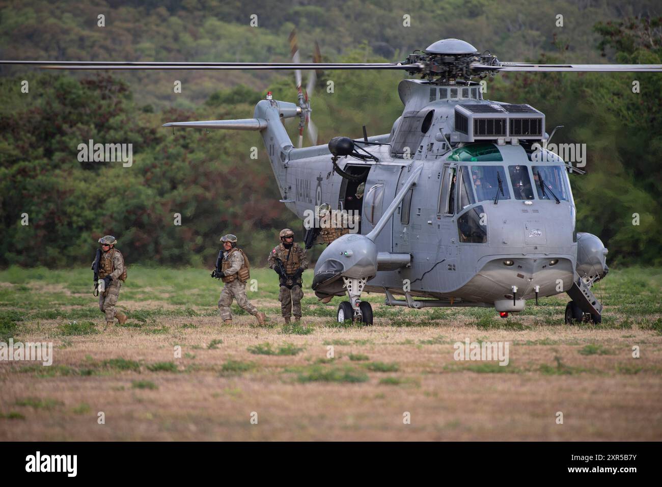 I Marines peruviani del 1° Battaglione, la Fanteria Navale Perù escono da un SH-3 Sea King prima di condurre una prova d'assalto aereo presso l'area addestramento dei Marines Bellows il 25 luglio 2024. Durante le prove, le forze partner di più nazioni furono unite dai Marines degli Stati Uniti durante l'esercitazione Rim of the Pacific (RIMPAC) nel tentativo di promuovere l'interoperabilità tra le forze di combattimento. Ventinove nazioni, 40 navi di superficie, tre sottomarini, 14 forze terrestri nazionali, più di 150 aerei e 25.000 personale partecipano al RIMPAC nelle e intorno alle isole Hawaii, dal giugno 27 al agosto 1. TH Foto Stock