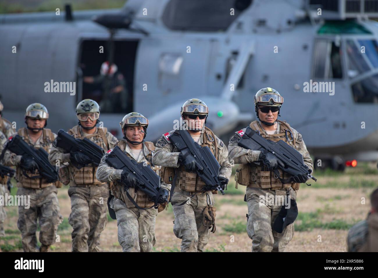 I Marines peruviani del 1° Battaglione, la Fanteria Navale Perù escono da un SH-3 Sea King prima di condurre una prova d'assalto aereo presso l'area addestramento dei Marines Bellows il 25 luglio 2024. Durante le prove, le forze partner di più nazioni furono unite dai Marines degli Stati Uniti durante l'esercitazione Rim of the Pacific (RIMPAC) nel tentativo di promuovere l'interoperabilità tra le forze di combattimento. Ventinove nazioni, 40 navi di superficie, tre sottomarini, 14 forze terrestri nazionali, più di 150 aerei e 25.000 personale partecipano al RIMPAC nelle e intorno alle isole Hawaii, dal giugno 27 al agosto 1. TH Foto Stock