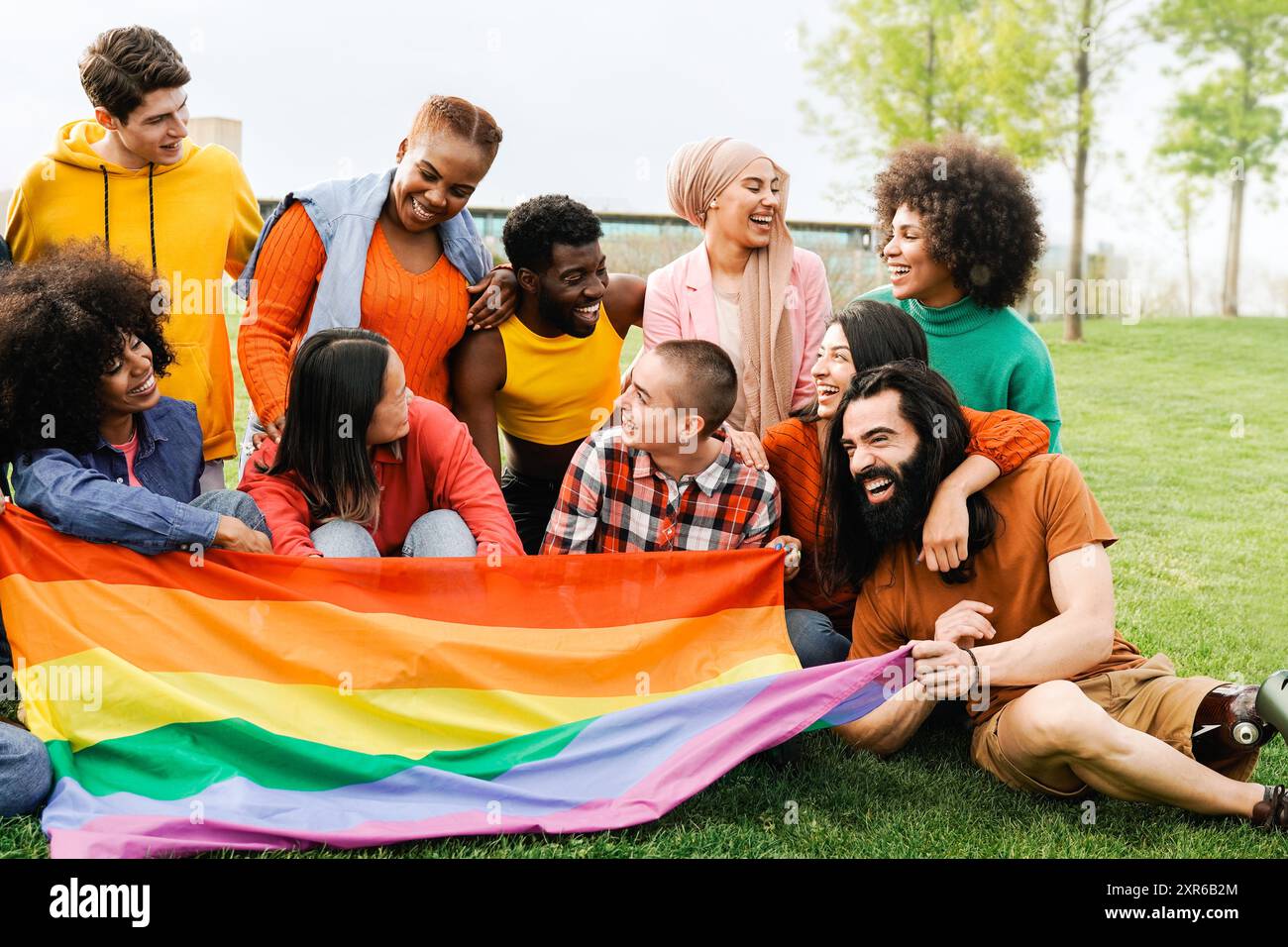 Le persone celebrano la festa arcobaleno che tiene la bandiera gay LGBTQ nella giornata estiva a Park City. Concentrati sulla donna nera. Concetto di diversità Foto Stock