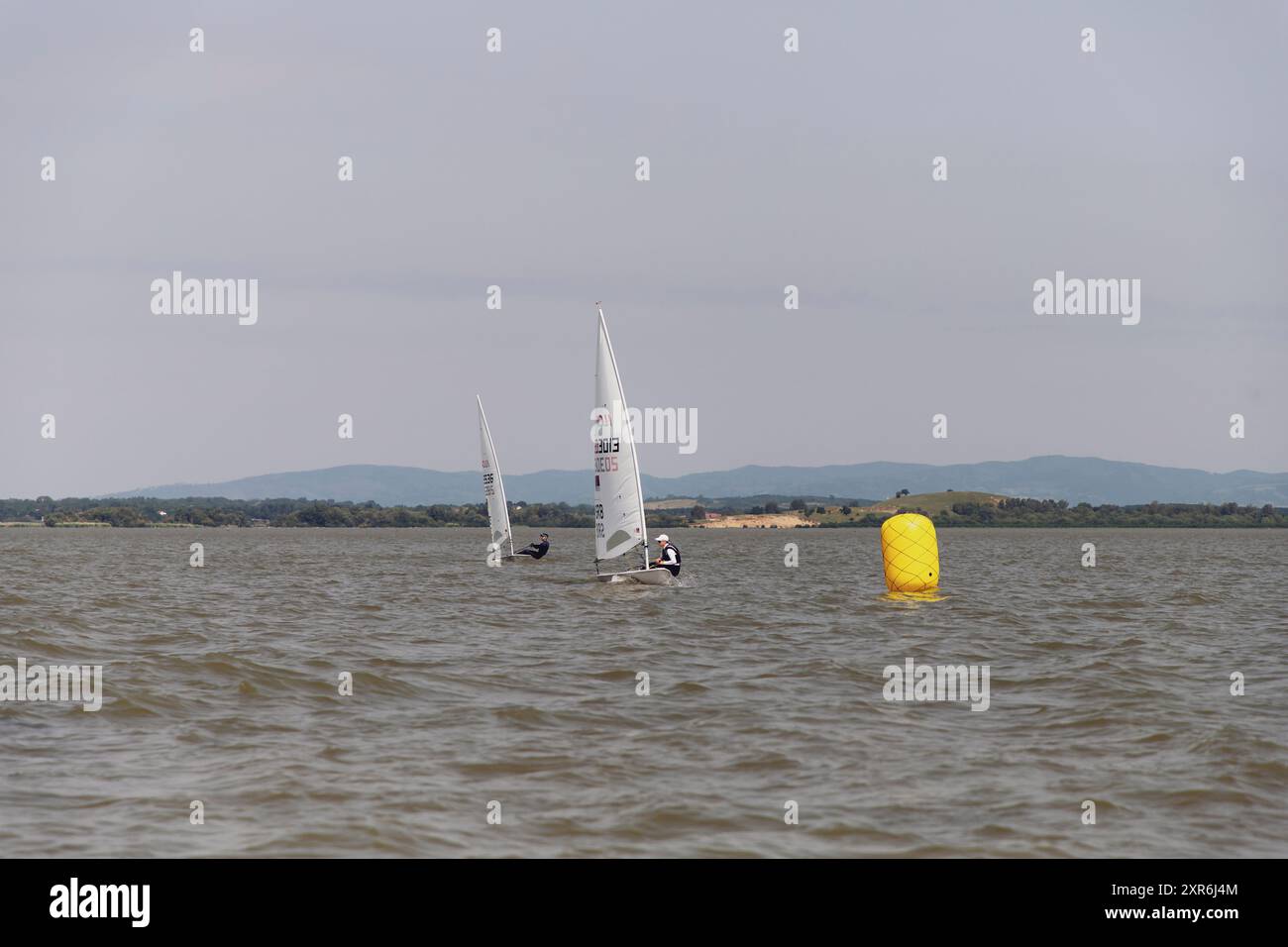 Golubac, Serbia, 9 giugno 2024: Le barche a vela si scontrano per la posizione in una regata a vela di classe laser sul Danubio. Foto Stock