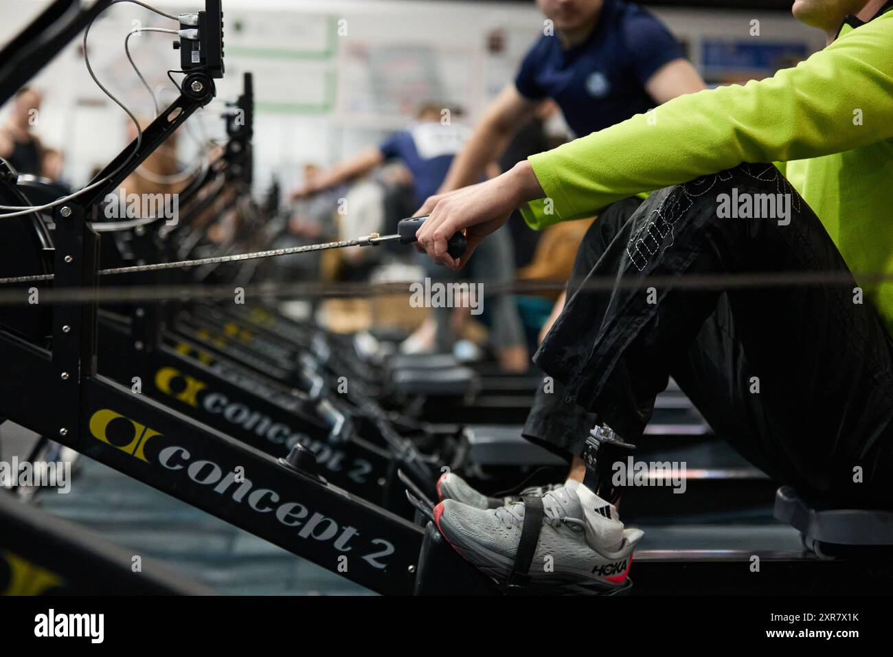 Atleta con amputazione che si allena su una macchina da canottaggio conct2 in palestra. Kiev - 13 dicembre 2023 Foto Stock