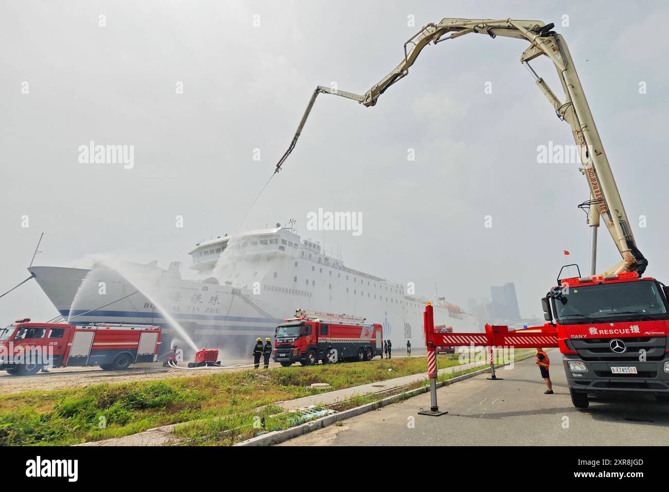YANTAI, CINA - 9 AGOSTO 2024 - le attrezzature antincendio svolgono attività antincendio e di soccorso su una nave danneggiata durante i mobilitati di difesa nazionale Foto Stock