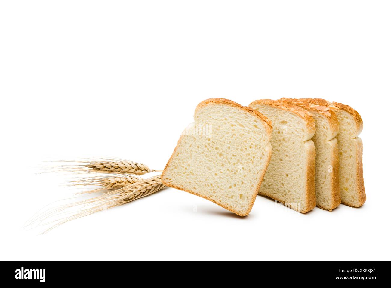 Fette di pane bianco con orecchie di grano su sfondo bianco. Foto Stock