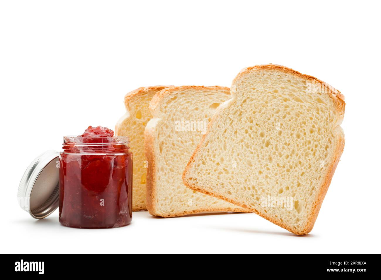 Fette di pane bianco con vasetto di marmellata di fragole su sfondo bianco. Foto Stock