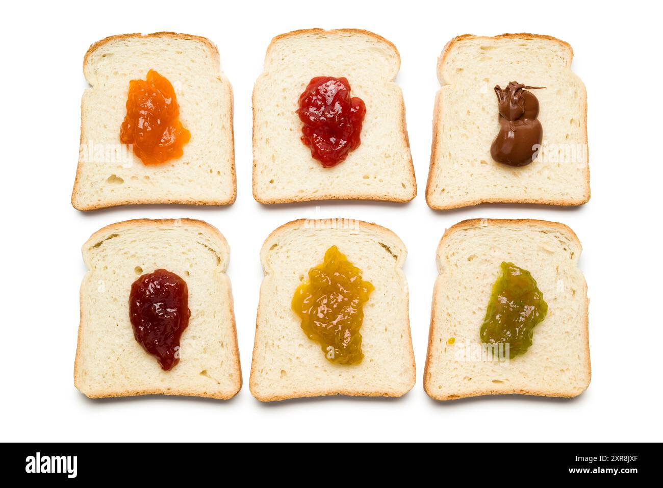Fette di pane bianco con vari tipi di marmellata su sfondo bianco, vista dall'alto. Foto Stock