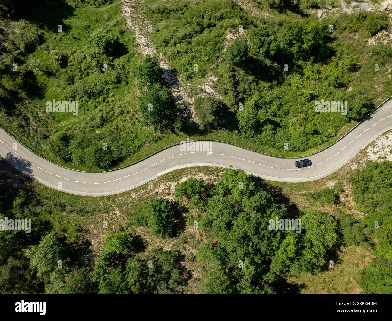 Vista aerea della strada tortuosa che attraversa la valle verso Gombrèn (Ripollès, Girona, Catalogna, Spagna, Pirenei) Foto Stock