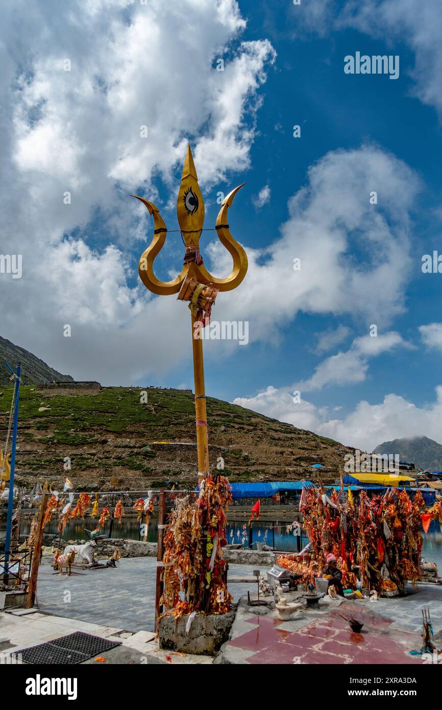 July25th2024, Himachal Pradesh, India. Panni rossi religiosi (chunri) e tridenti (trishul), simboli del Signore Shiva, contro Kailash Parvat durante il Foto Stock