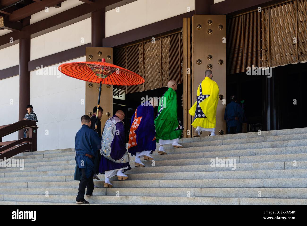 Narita, Giappone - 23 luglio 2024: Sacerdoti che camminano verso la sala principale del tempio Naritasan Shinsho-ji vicino a Tokyo in Giappone in un giorno estivo di sole Foto Stock