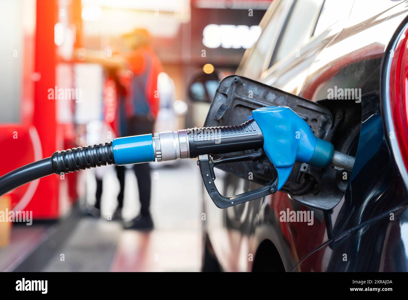 Rifornire di carburante le auto alla pompa carburante. Il conducente deve fare il pieno di carburante e pompare la benzina dell'auto con carburante alla stazione di rifornimento. Rifornimento di auto presso una stazione di servizio. OI Foto Stock