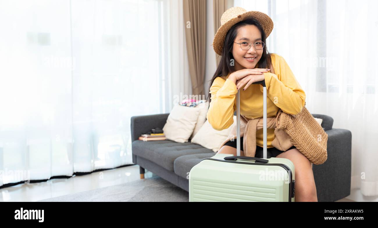 Ritratto di una donna viaggiatrice asiatica che fa il pieno di zaini prepara roba e vestiti in valigie borse da viaggio bagagli per l'estate, le vacanze, le piume Foto Stock