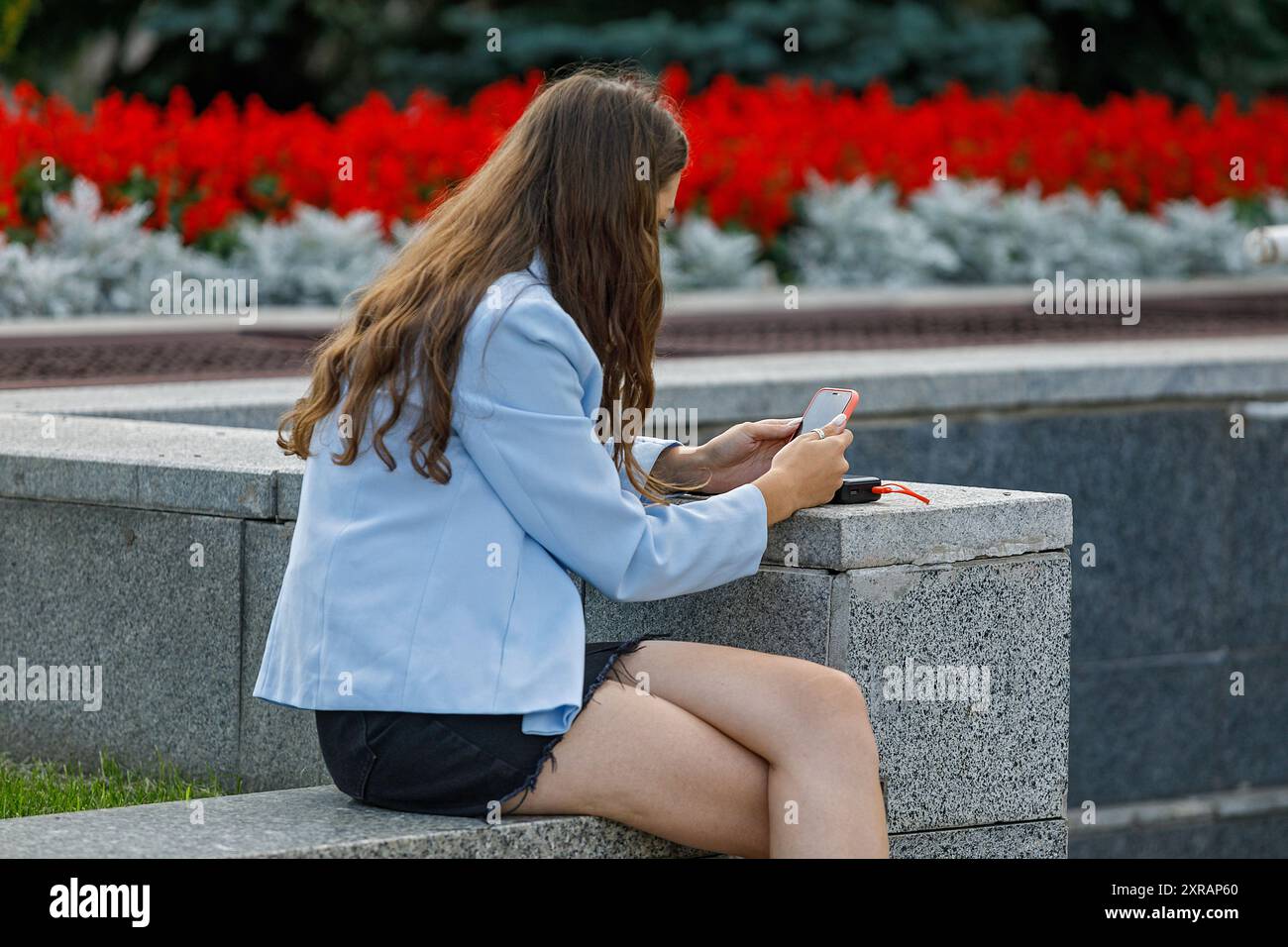 KIEV, UCRAINA - 9 AGOSTO 2024 - Una donna utilizza uno smartphone per strada nel centro di Kiev, capitale dell'Ucraina. Foto Stock