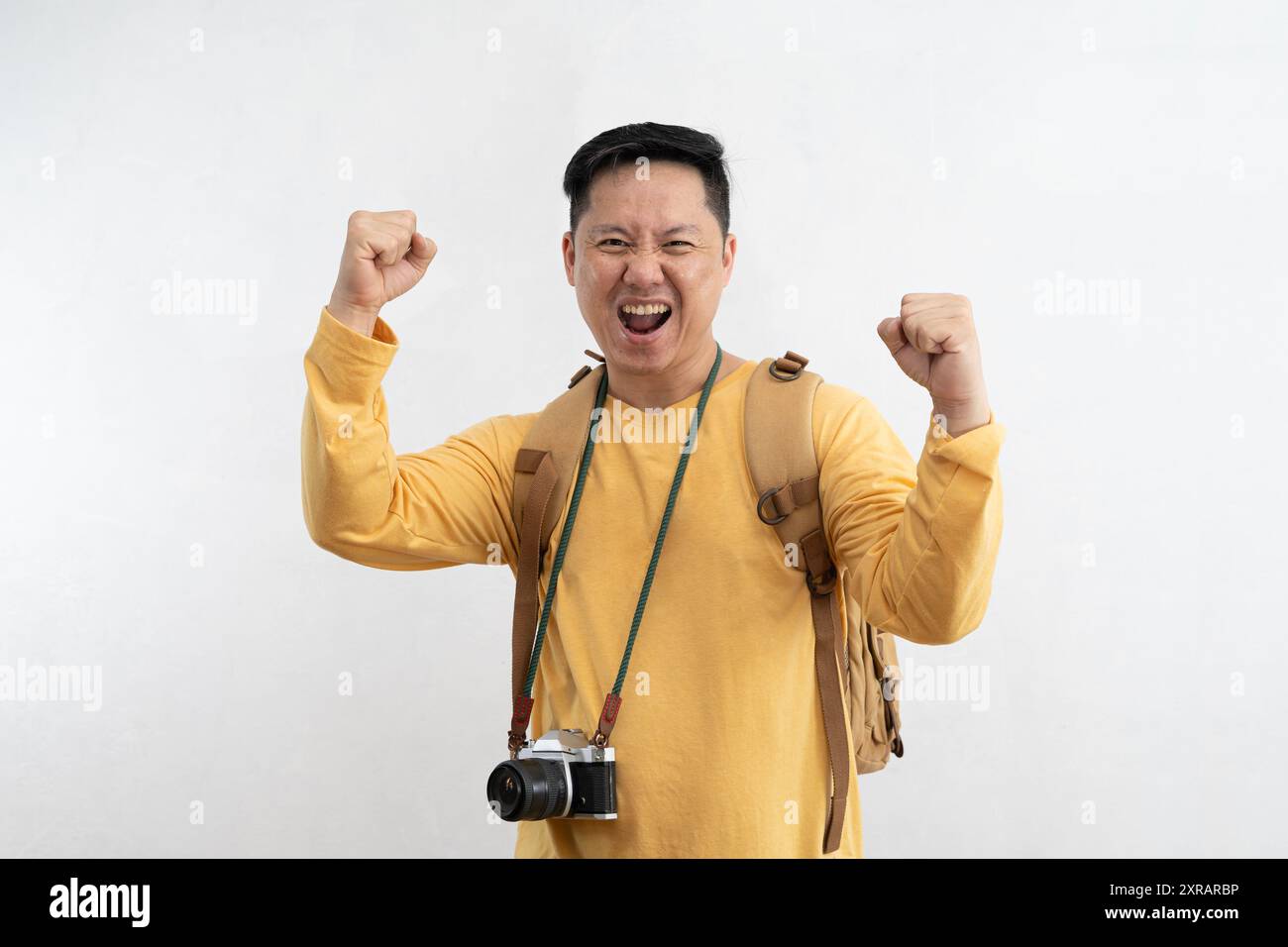 Il turista entusiasta in una fotocamera a cappello che si posa per celebrare il pugno stringato dice di sì isolato su sfondo bianco. Passeggeri che viaggiano all'estero nei fine settimana A. Foto Stock