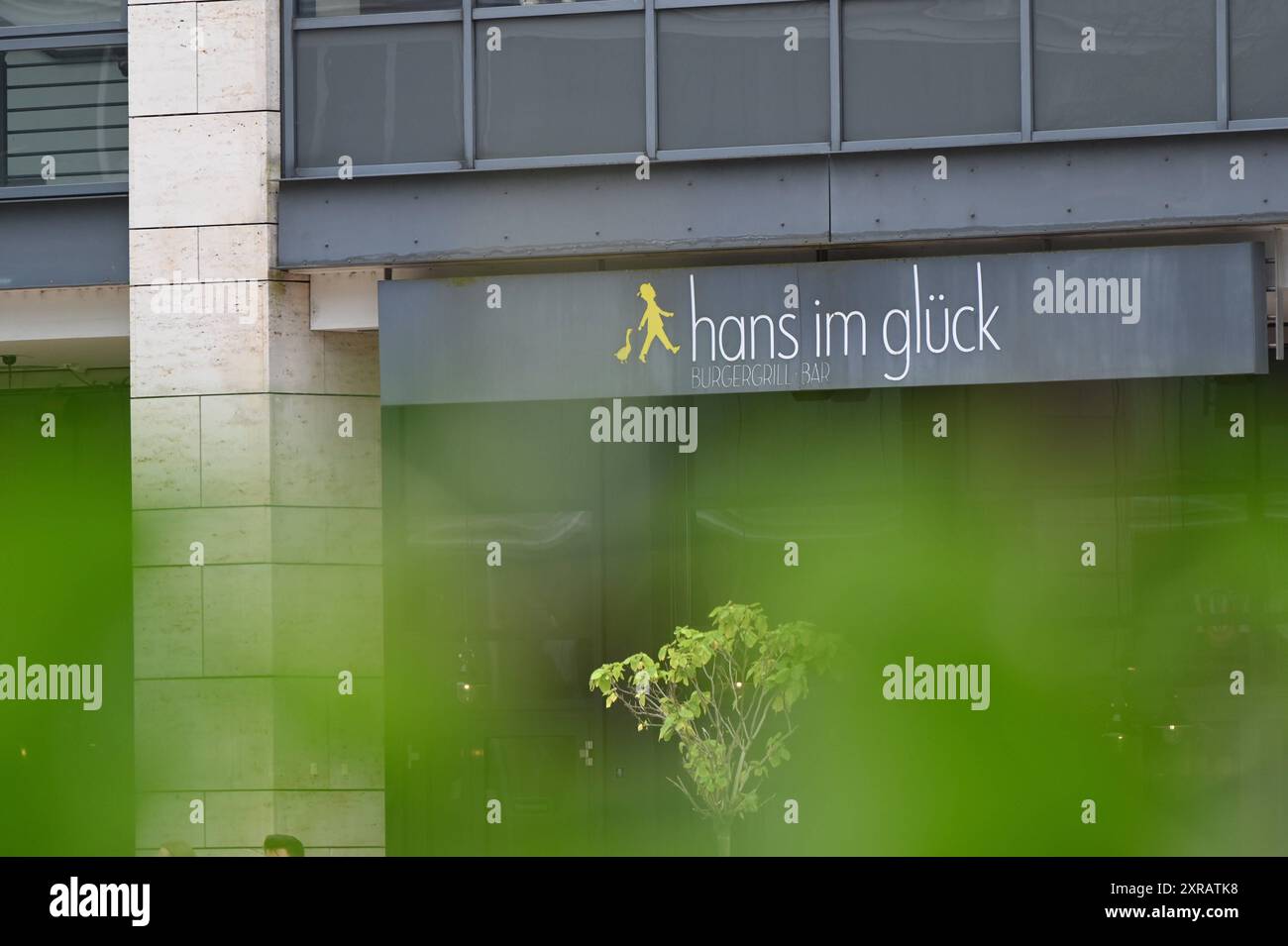 Logo, Schrifttzug an einer Filiale von Hans im Glück, ein deutsches Franchising Unternehmen der Systemgastronomie für Burger *** Logo, scritta su una filiale di Hans im Glück, una società tedesca di franchising nel settore della ristorazione di sistemi per hamburger Foto Stock