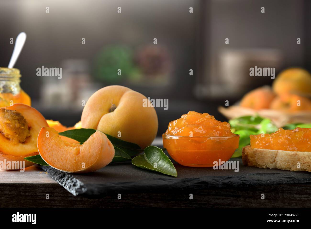 Dettagli di pesca e marmellata di frutta con una cucina scura sullo sfondo. Vista frontale. Foto Stock