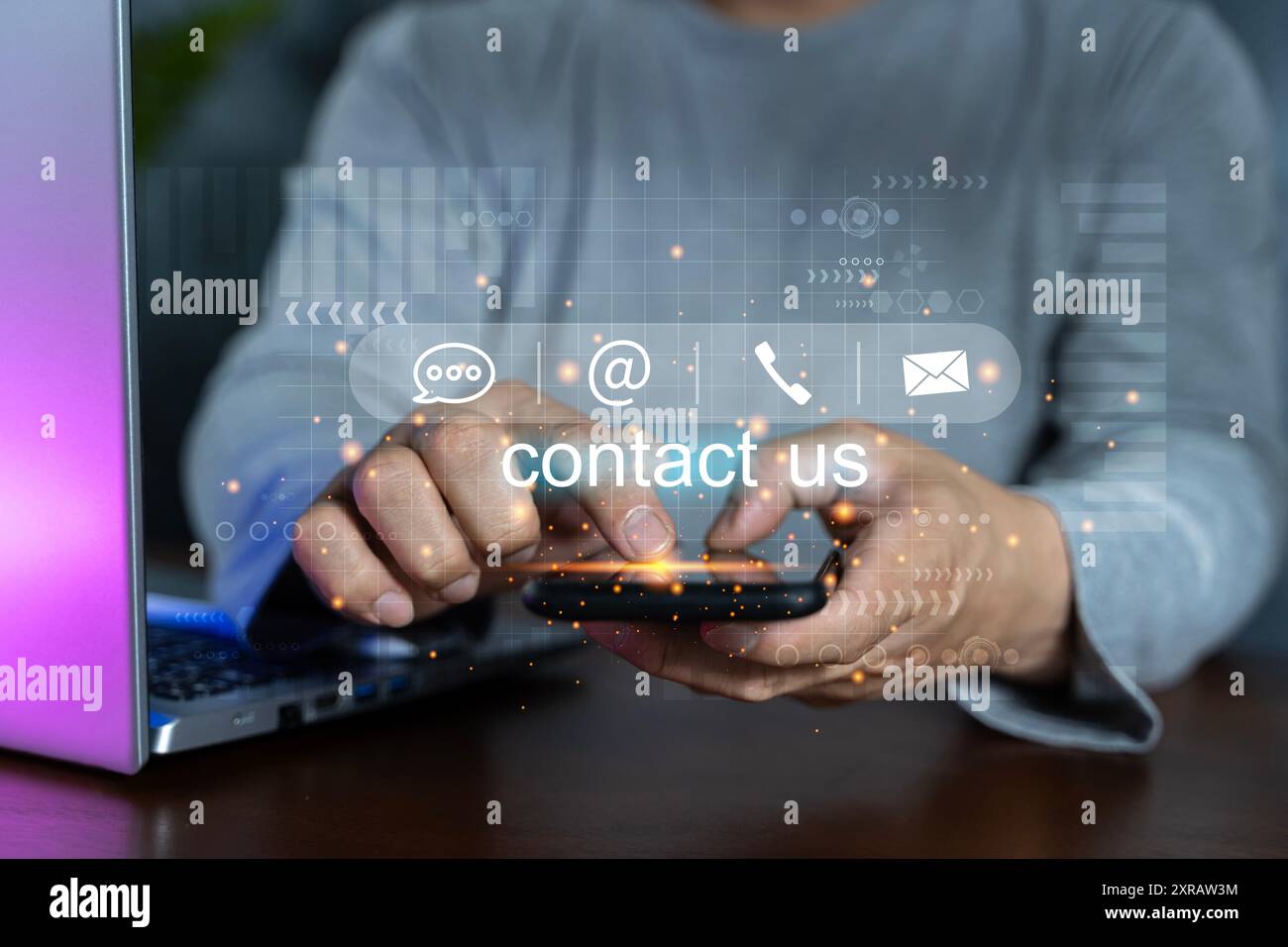 Contattaci o contatta il servizio di assistenza clienti. Uomo d'affari che utilizza smartphone, laptop e tocca le icone dei contatti sullo schermo virtuale. Sito Web e. Foto Stock