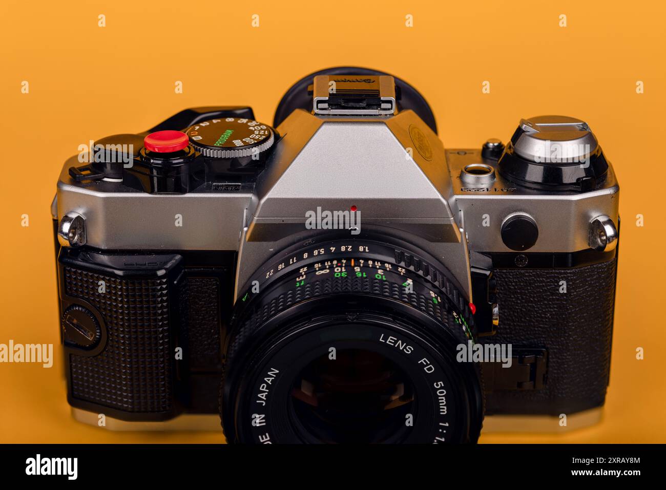 Primo piano dettagliato della parte superiore di una vecchia fotocamera, con le sue caratteristiche classiche ben visibili su uno sfondo giallo. Foto Stock