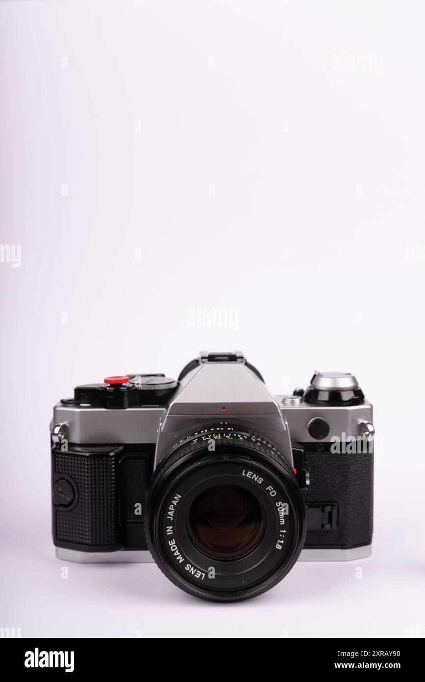 Una fotocamera antica posizionata centralmente su uno sfondo bianco. Il formato verticale mette in risalto il design classico della fotocamera, enfatizzando i suoi tempi Foto Stock