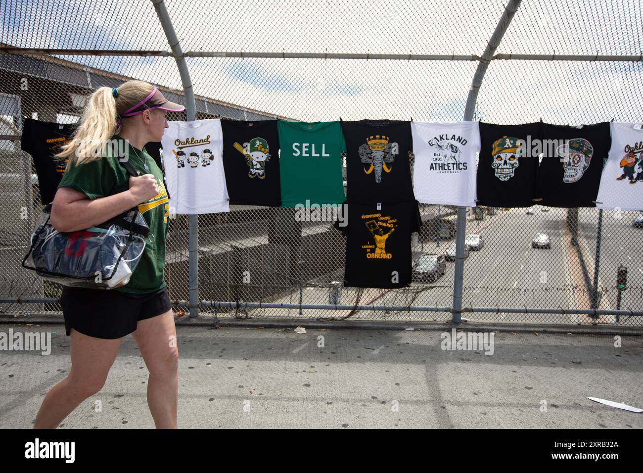 OAKLAND, CALIFORNIA - 04 AGOSTO: Un tifoso cammina con t-shirt vendute fuori dallo stadio prima della partenza tra gli Oakland Athletics e i Los Angeles Dodgers all'Oakland Coliseum il 4 agosto 2024 a Oakland, California. (Foto di Michael Yanow/immagine dello sport) Foto Stock