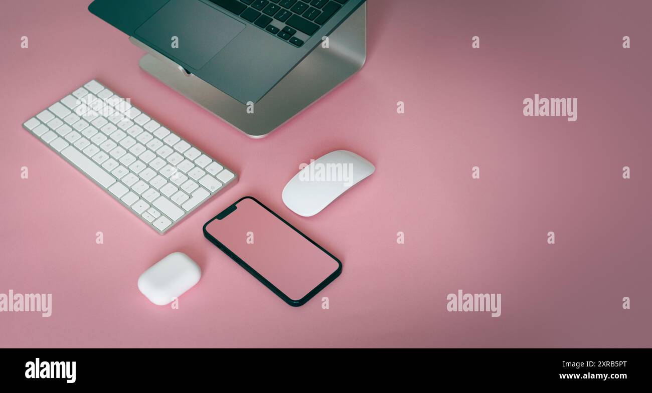 Laptop e smartphone. Vista dall'alto composizione geometrica su sfondo rosa. Modello con schermo vuoto. Foto Stock