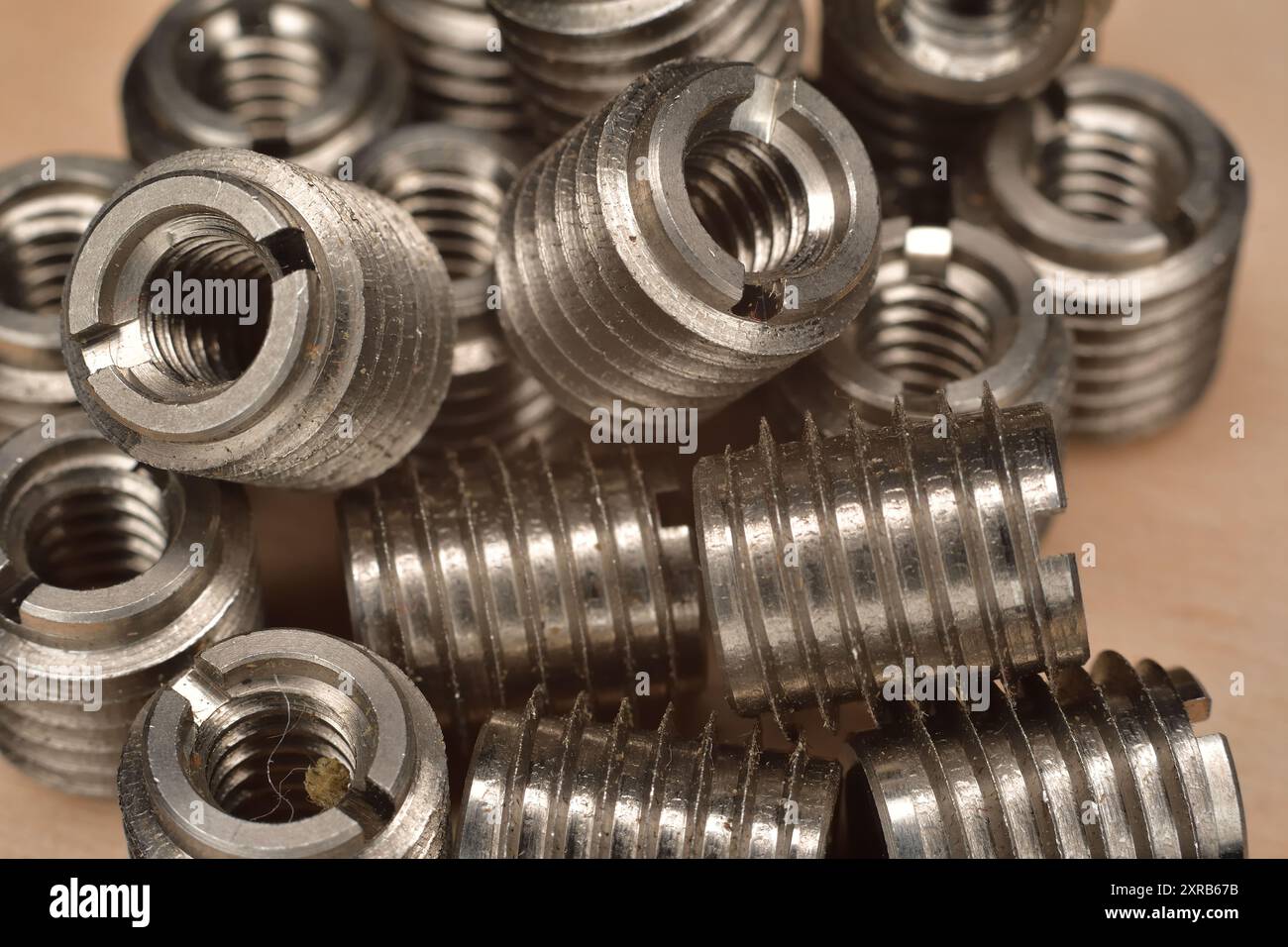 Inserto in legno con filettatura fine in acciaio inox. Inserto filettato per pannelli compositi e polimerici. Inserto filettato 1/4-20 NC interno. Primo piano di acciaio inossidabile Foto Stock