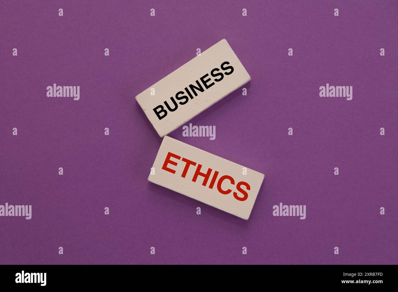 Due blocchi di legno con scritto "business" e "Ethics", che suggeriscono l'importanza delle pratiche commerciali etiche. Foto Stock