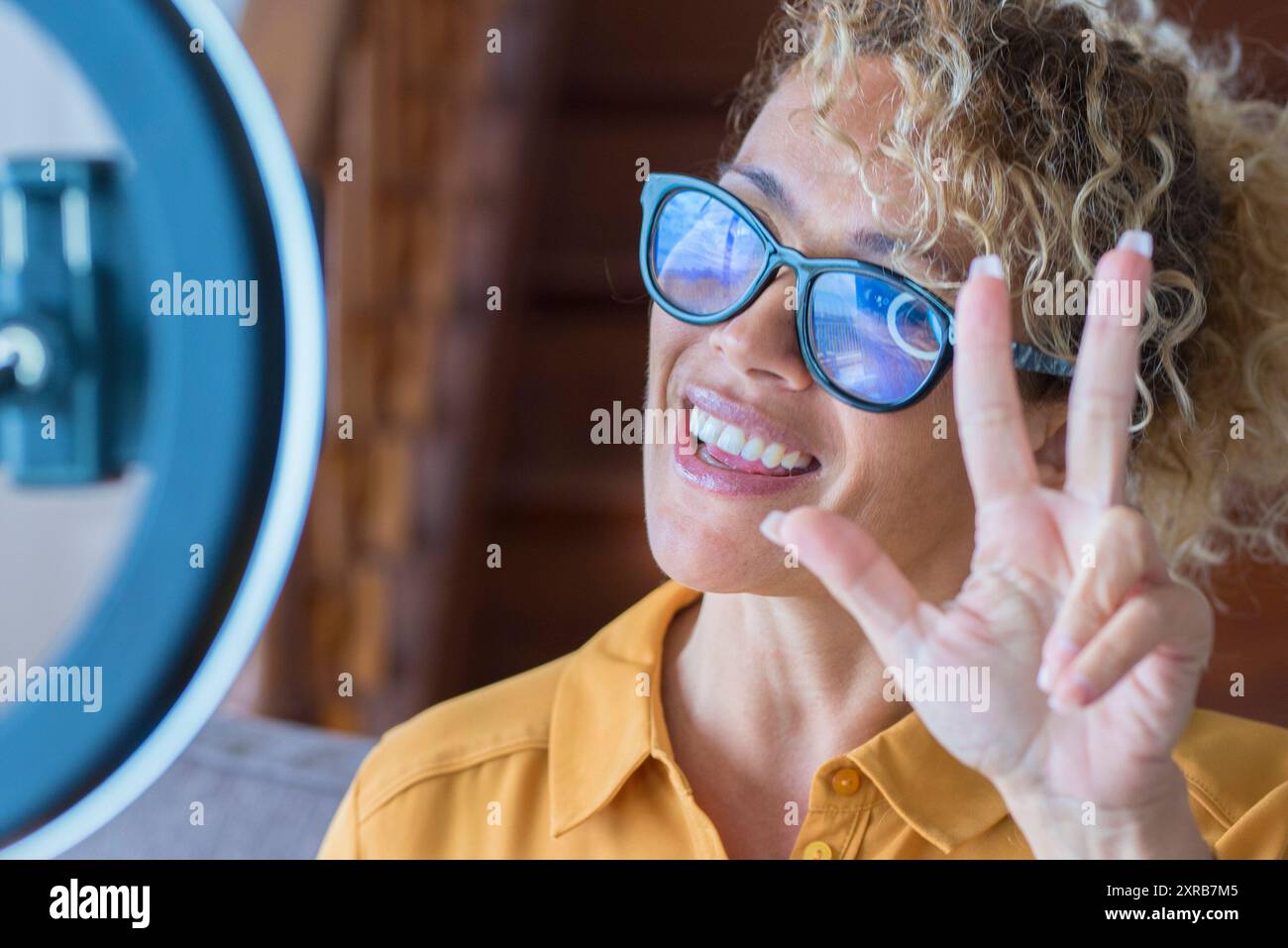 Ritratto di bella donna adulta che parla di fronte a telefono per registrare contenuti online - concetto di casa moderna lavoro e creatore digitale - videochiamata Foto Stock