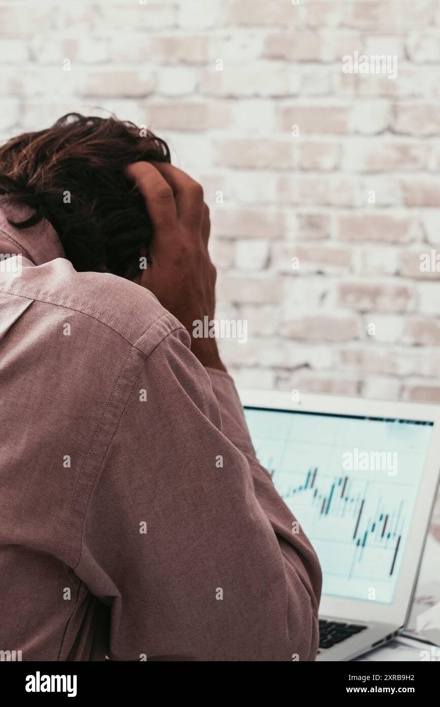 Uomo disperato contro la cripto-economia di borsa grafico su notebook. Perdere soldi con il commercio in linea. Attività di investimento di persone ed economia. Attività di mercato valutario non riuscita Smart Working Foto Stock