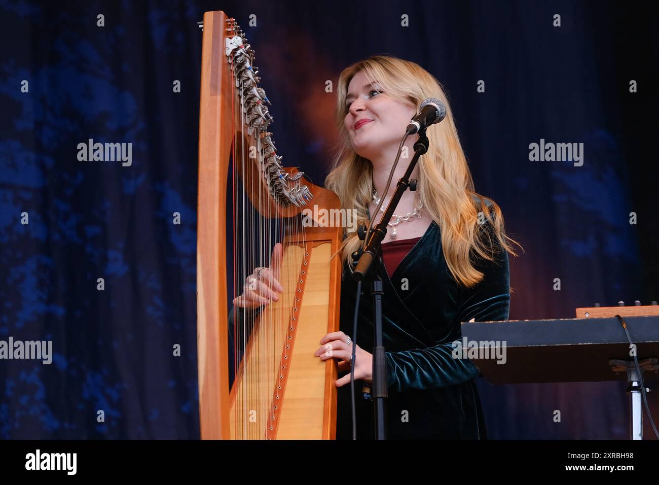 Williamscot, Regno Unito. 8 agosto 2024. Josie Duncan arpa e voce che si esibiscono dal vivo sul palco con Kathryn Tickell e The Darkening alla Cropredy Convention. Kathryn Tickell è una compositrice, interprete ed educatrice. Il Darkening, che prende il nome dalla vecchia parola northumbriana per il crepuscolo, comprende quattro membri con sede nel nord-est dell'Inghilterra Amy Thatcher, Joe Truswell alla batteria, Kathryn Tickell alla voce e alle pipe settentrionali, Kieran Szifris alla chitarra e al mandolino, Josie Duncan arpa e voce. (Foto di Dawn Fletcher-Park/SOPA Images/Sipa USA) credito: SIPA USA/Alamy Live News Foto Stock